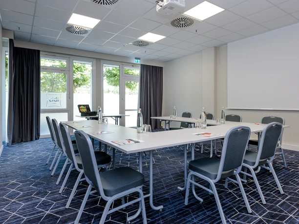 ibis Hotel Frankfurt Messe West - Meeting room Meeting room with U-table and blue carpet.