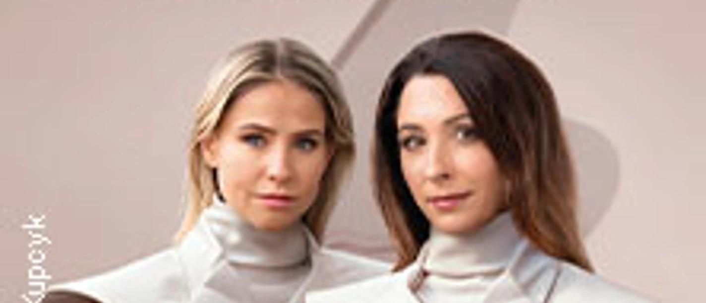 Zwei Frauen in futuristischen Outfits vor einem stilisierten Klavierhintergrund.