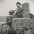 01 Heinrich Jansen....jpg Schwarzweißfoto eines Soldaten in Uniform, der an einem Grenzstein sitzt.