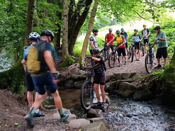 Gruppe Mountainbiker bei Bachüberquerung