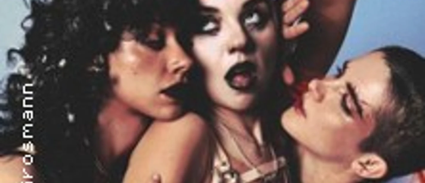 Drei Performer posieren eng nebeneinander mit ausdrucksstarken Gesichtszügen.