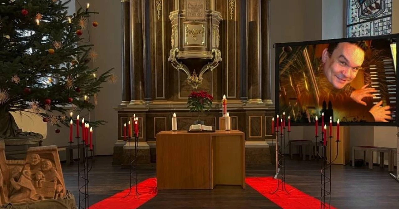 Organ fireworks Candlelight concerts.jpg Altar mit Kerzen, Weihnachtsbaum und großem Bildschirm mit spielender Person.Altar with candles, Christmas tree and large screen with a person playing.