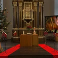 Orgelfeuerwerk Kerzenschein Konzerte.jpg Altar mit Kerzen, Weihnachtsbaum und großem Bildschirm mit spielender Person.Altar with candles, Christmas tree and large screen with a person playing.