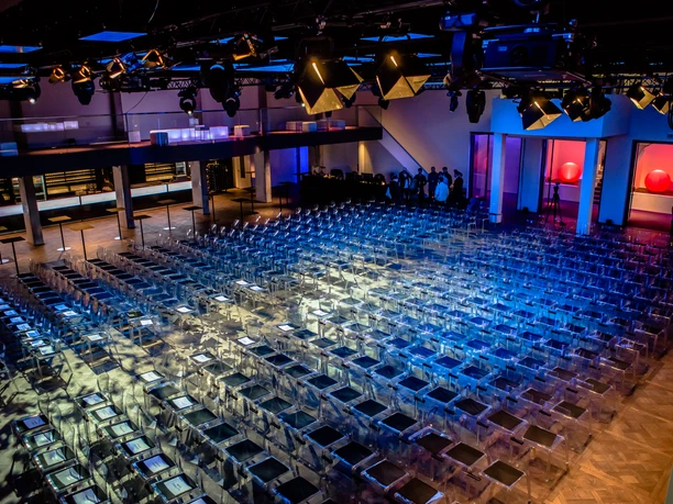 PALAIS FRANKFURT - Event hall Large hall with row seating and illuminated stage.