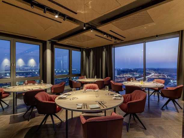 b'mine Frankfurt Airport - Restaurant Restaurant mit roten Sesseln und Flughafenblick.