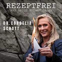 Dr. Cordelia Schott hält ein brennendes Blatt vor einer dunklen Felswand in der Hand.
