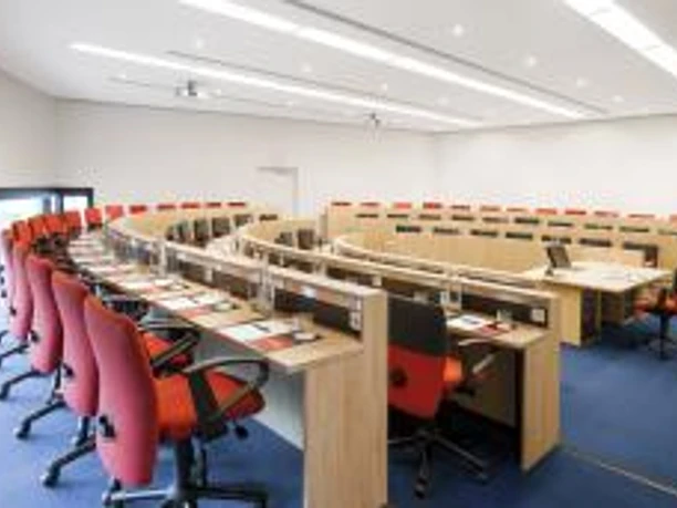 Intercity Hotel Frankfurt Airport - 180 ° Hörsaal mit halbrunden Tischreihen und roten Stühlen.