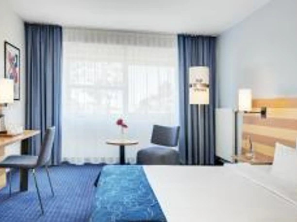 Intercity Hotel Frankfurt Airport - Hotel rooms Hotel room with desk and blue accents.