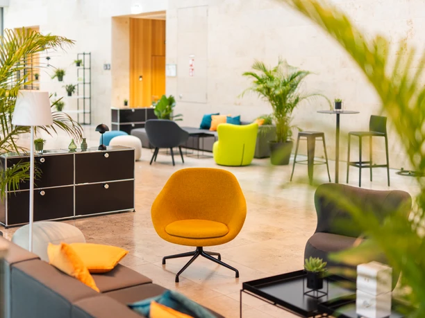 Rent.Group Frankfurt Eichenberger GmbH - various seating options Room with colour-coordinated seating and green plants.