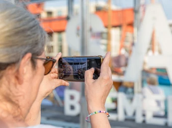S0723 (c) Helmut Gross_Erlebnis Bremerhaven.jpg Person fotografiert mit dem Smartphone den Selfie-Point mit großen Buchstaben in Bremerhaven.