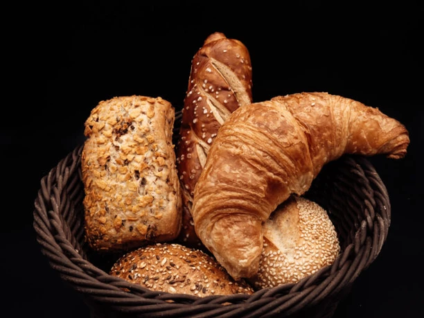 Brötchenkorb_Bäckerei Ripken.jpg Korb mit verschiedenen Brötchen und Croissant aus der Holzofenbäckerei Ripken vor dunklem Hintergrund