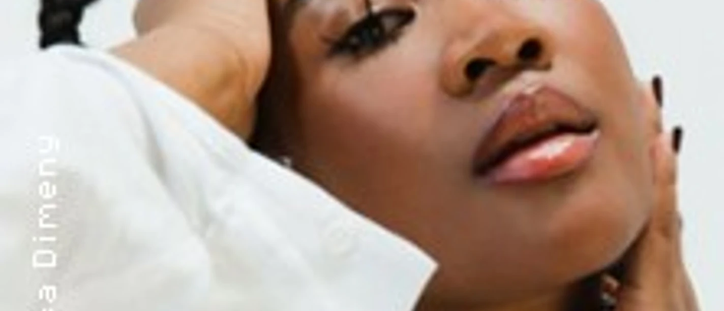 Rose May Alaba im Porträt mit weißem Oberteil und modischem Perlenkragen.