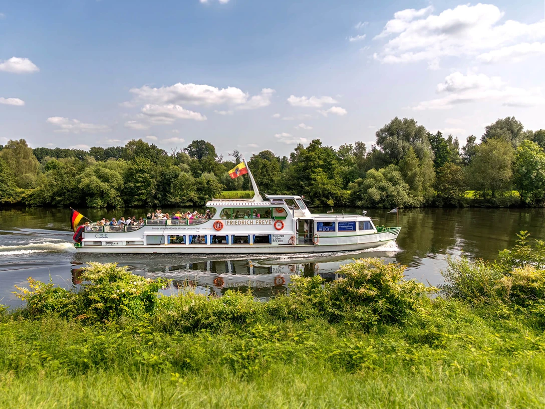 Linienfahrt im Ruhrtal, Weiße Flotte Mülheim an der Ruhr Schiff mit Aufschrift „MS Friedrich Freye” fährt im Sommer auf einem Fluss durch das Mülheimer Ruhrtal