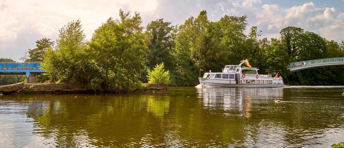Linienfahrt am Kahlenberg, Weiße Flotte Mülheim an der Ruhr Schiff mit Aufschrift „MS Friedrich Freye” fährt im Sommer auf einem Fluss vorbei am Kahlenbergwehr in Mülheim
