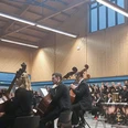 Landesjugendorchester Bremen in Hambergen Orchester und großer Chor treten in einer holzverkleideten Sporthalle auf.