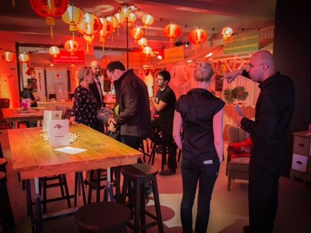 Ape's Cooking Academy - Location Menschen stehen in einemdekorierten Raum während einer Veranstaltung.