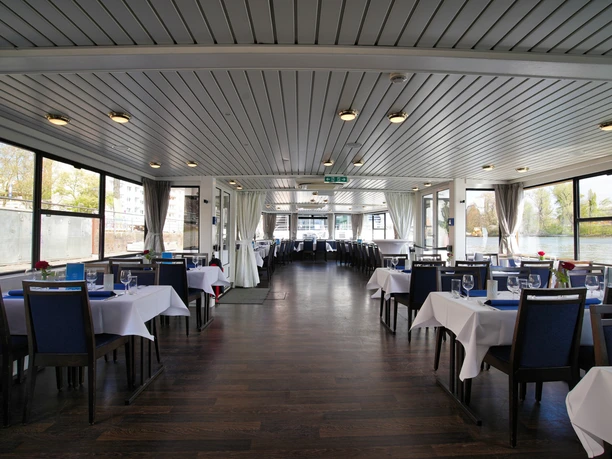 Event-Schiff & Rundfahrten Frankfurt - Innenansicht Event-Schiff Innenraum eines Event-Schiffs mit eingedeckten Tischen, bereit für ein gemeinsames Essen.