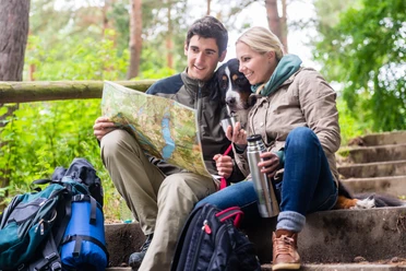 Man and woman on hike planning next route section on map