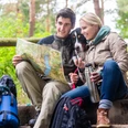 Man and woman on hike planning next route section on map