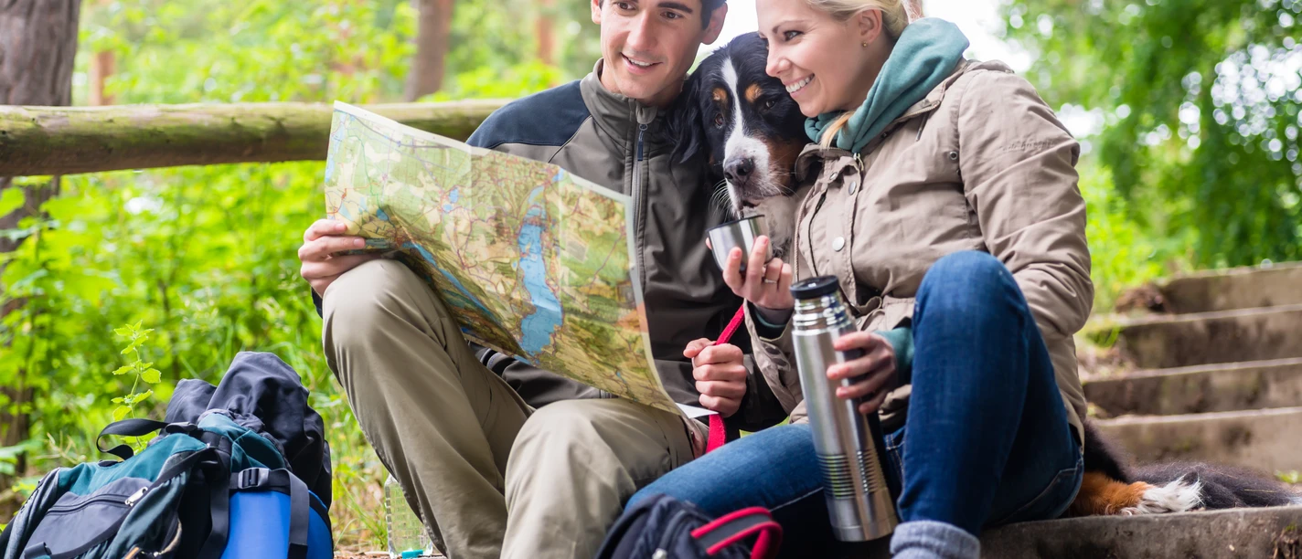 Man and woman on hike planning next route section on map