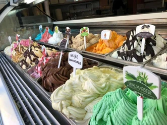 eiscafe-venezia.jpg Bunte Eistheke mit verschiedenen Sorten wie Stracciatella, Waldmeister und weißer Schokolade.