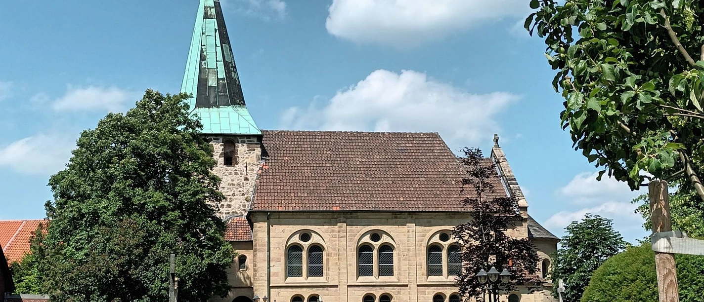 Evangelische Kirche in Groß Mahner mit grünem Turmhelm, Sandsteinmauern und gepflegtem Kirchhof.