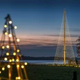 weihnachtsleuchtturm-jagdhaus-eiden.jpg Leuchtturm-Tanne aus Lichterketten am Ufer des Zwischenahner Meers bei Abenddämmerung.