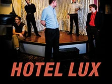 Fünf Personen stehen auf einer Bühne vor einem silbernen Vorhang im Hotel Lux.