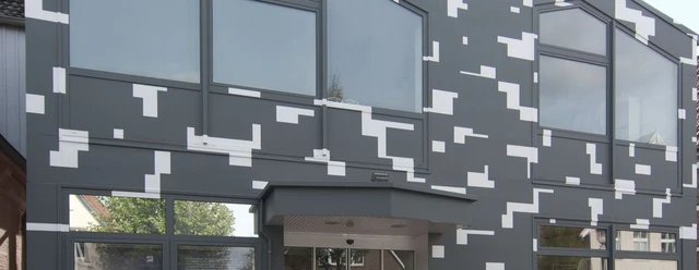 Museum gegenstandsfreier Kunst.jpg Graue Museumsfassade mit weißen Quadraten, großen Glasfenstern und modernem Eingangsbereich