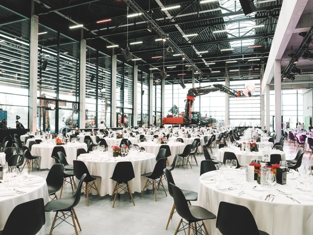 Coreum Eventlocation - Große Industriehalle Große Industriehalle mit Bankettbestuhlung und Baumaschinen.