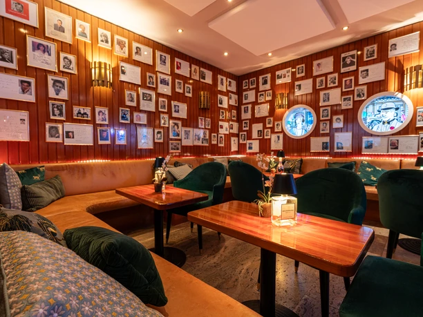 Parkhotel Bad Homburg - Interior view of the bar Hotel bar with wooden walls, lots of photos and cozy seating areas.