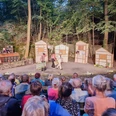 Naturbühne Maxen Freilichttheateraufführung im Wald mit Zuschauern und Schauspielern auf der Bühne.
