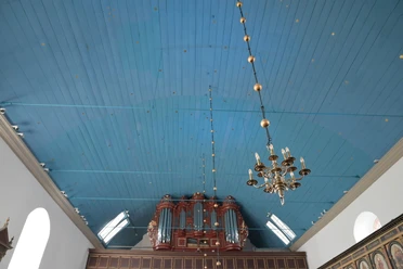DSC_1944.JPG Blick auf die blaue Holzdecke einer Kirche mit kunstvoller Orgel und hängendem Kronleuchter.