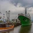 DSC00724 (c) Birgit Hass_Erlebnis Bremerhaven.jpg Krabbenkutter und grünes Schiff im Hafen von Bremerhaven vor grauem Himmel und rotem Leuchtturm