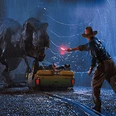 Jurassic-Park.png Ein T-Rex vor einem Jeep, während ein Mensch eine Fackel hält, bei Nacht.A T-Rex in front of a jeep while a human holds a torch, at night.