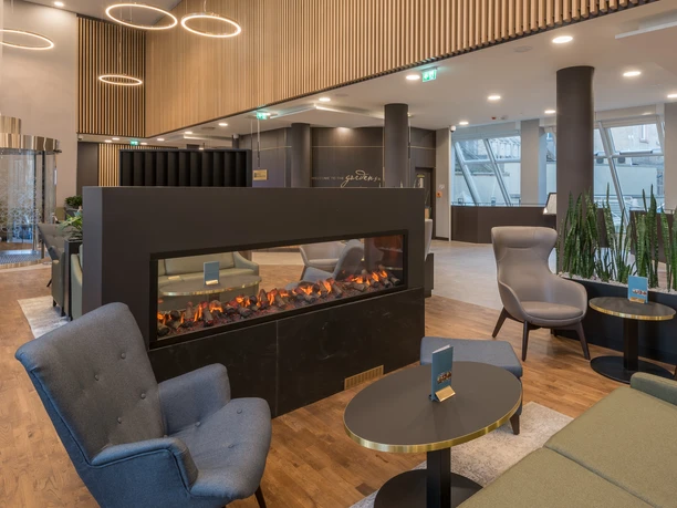 Hilton Garden Inn Frankfurt City - Hotellobby Moderne Hotellobby mit Kamin, gemütlichen Sitzbereichen und stilvollem Design.