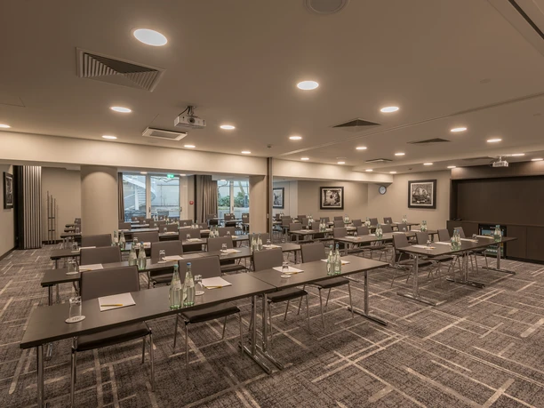 Hilton Garden Inn Frankfurt City - Seminar room Bright seminar room with row seating, projector, large windows and modern conference technology.