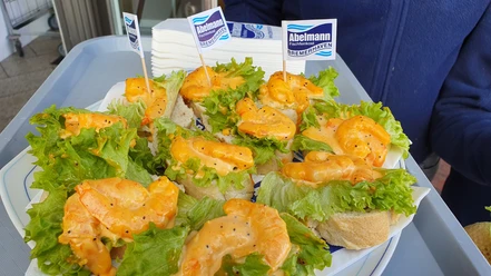 Fisch-Happen-Tour 20210422_114518 (c) Tanja Mehl_Erlebnis Bremerhaven.jpg Brote mit Garnelen, grünen Salatblättern und würziger Sauce, serviert auf einem Tablett.