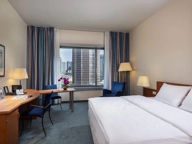 Maritim Hotel Frankfurt - Hotelzimmer Helles Hotelzimmer mit Doppelbett, Schreibtisch und Blick auf die Stadt