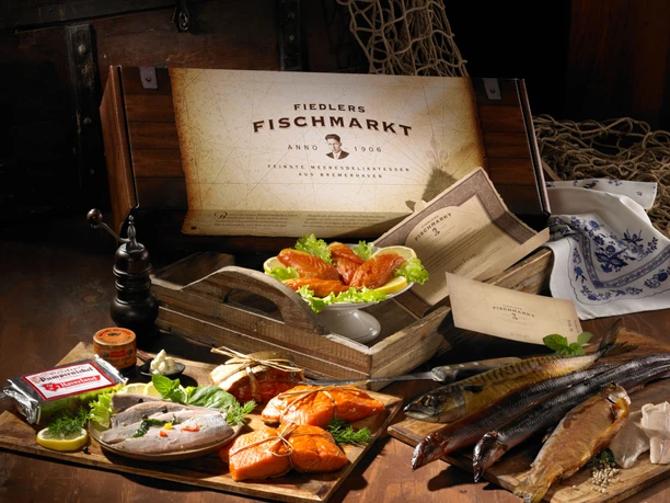 H.-J. Fiedler Meeresdelikatessen, Geschenkverpackung_03 (c) H.-J. Fiedler Meeresdelikatessen.jpg Geschenkbox mit geräuchertem Fisch, frischen Meeresdelikatessen und maritimer Dekoration.