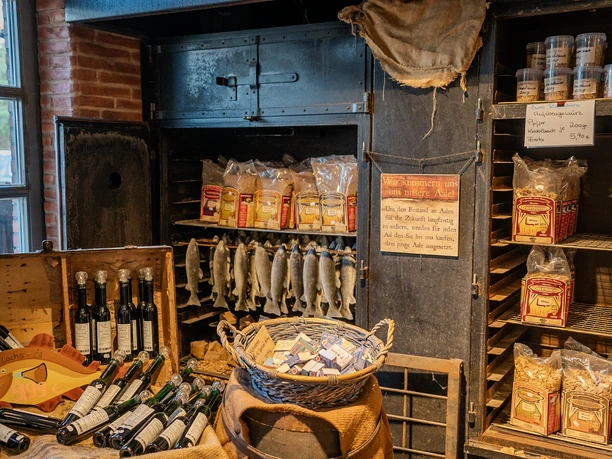 bremerhaven 02969 (c) Tanja Neumann IG_vielweib.jpg Verkaufsraum mit Räucherfischen, Fischölflaschen, Gewürzen und Räuchermehl in rustikalem Ambiente