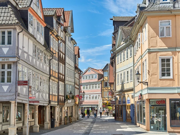Blick in die Krambuden Enge Fußgängerzone in Wolfenbüttel mit historischen Fachwerkhäusern unter blauem Himmel.