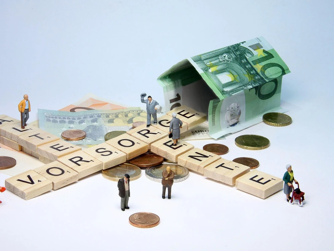 Rentenberatung-DRV.jpg Miniaturfiguren auf Geld und Scrabble-Steinen.