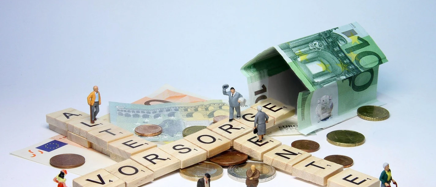 Rentenberatung-DRV.jpg Miniaturfiguren auf Geld und Scrabble-Steinen.