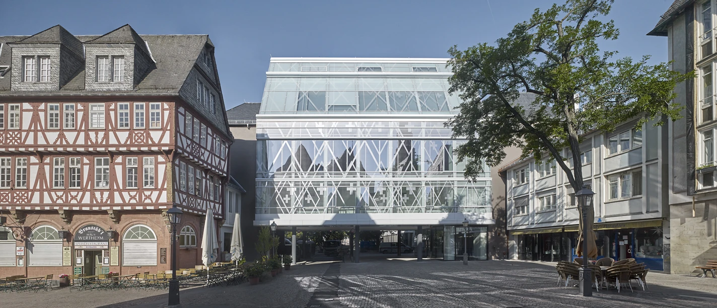 Evangelische Akademie - Exterior view Modern glass façade of the Evangelische Akademie beside historic timber-framed houses
