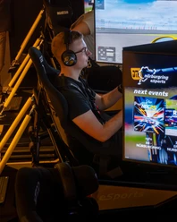 Nürburgring E-Sports SimRacing Lounge A young man with a headset drives virtually in the Nürburgring E-Sports SimRacing Lounge.