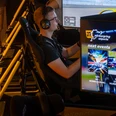 Nürburgring E-Sports SimRacing Lounge Ein junger Mann mit Headset fährt virtuell in der Nürburgring E-Sports SimRacing Lounge.A young man with a headset drives virtually in the Nürburgring E-Sports SimRacing Lounge.