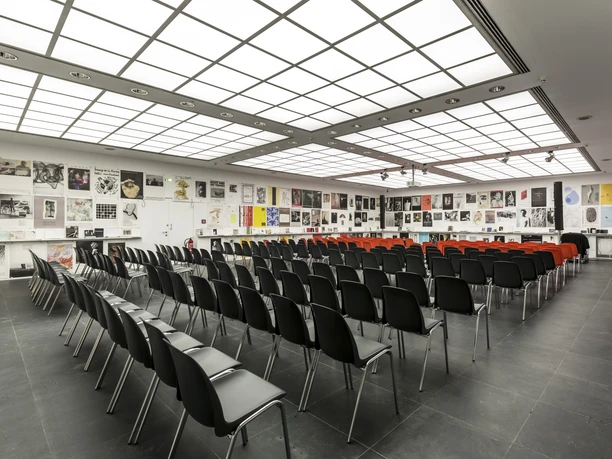 Frankfurter Kunstverein - Auditorium Saal mit Reihenbestuhlung und Kunstpostern an den Wänden