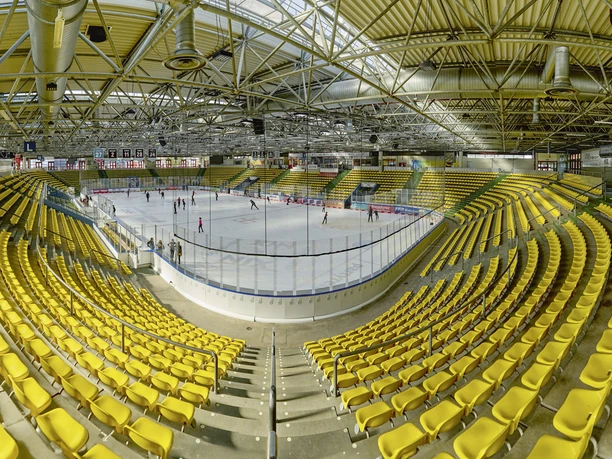 Eissporthalle Frankfurt - Interior view of the ice rink Interior view of the ice rink: bright ice rink with surrounding yellow rows of seats and steel construction.