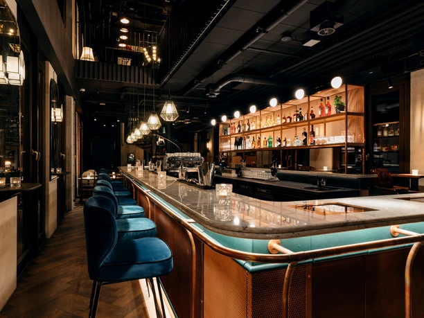Ruby Louise Hotel Frankfurt - Bar Hotelbar am Abend mit einem Bartresen und blauen Barhockern